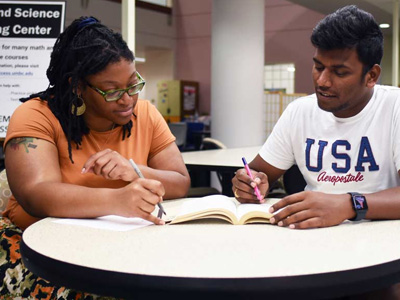 Two students working together on an assignment in the college library