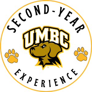 Second-year experience logo. UMBC retriever with two gold paw prints.